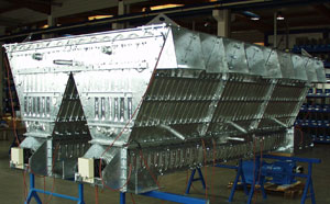 Großer, verzinkter Reihenfilter in einer Werkhalle, bestehend aus mehreren trapezförmigen Filtermodulen, montiert auf einem blauen Stahlgestell.