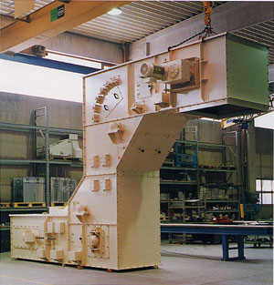 Großer, cremefarbener Flexowell-Gurtförderer mit mehreren Antriebs- und Umlenkmodulen, montiert in einer Werkhalle und teilweise an einem Kran eingehängt.